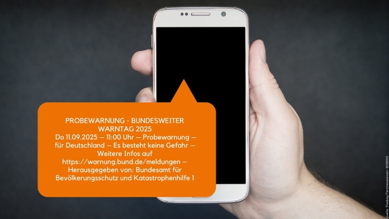 Beispiel einer Cell-Broadcast-Warnmeldung zum bundesweiten Warntag 2025 auf einem Smartphone-Bildschirm mit orangefarbener Hinweisbox.