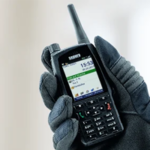 Handfunkgerät wird mit Handschuh getragen und bedient. Auf dem Display sind Einsatzinformationen zu sehen, das Gerät wird zur Kommunikation im Einsatz genutzt.