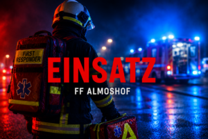 Feuerwehrangehöriger mit First-Responder-Ausrüstung steht bei Nacht auf einer nassen Straße vor Einsatzfahrzeugen mit Blaulicht; Schriftzug „Einsatz FF Almoshof“.